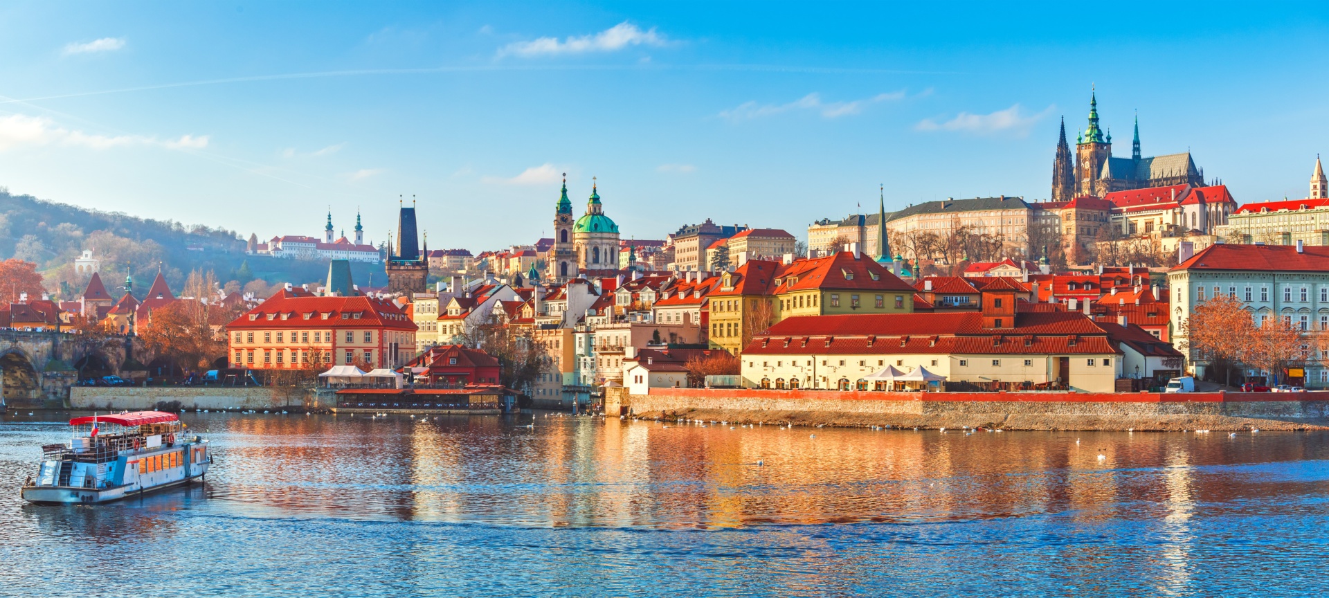 reka Vltava, čoln na reki, jasno nebo in praški grad v ozadju