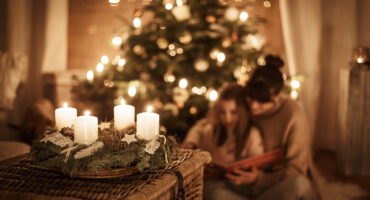 Child,Sits,With,Mother,In,Front,Of,The,Christmas,Tree